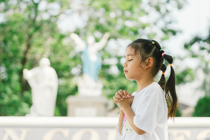 little-asian-girl-praying-god-park-religion-concept_69769-926